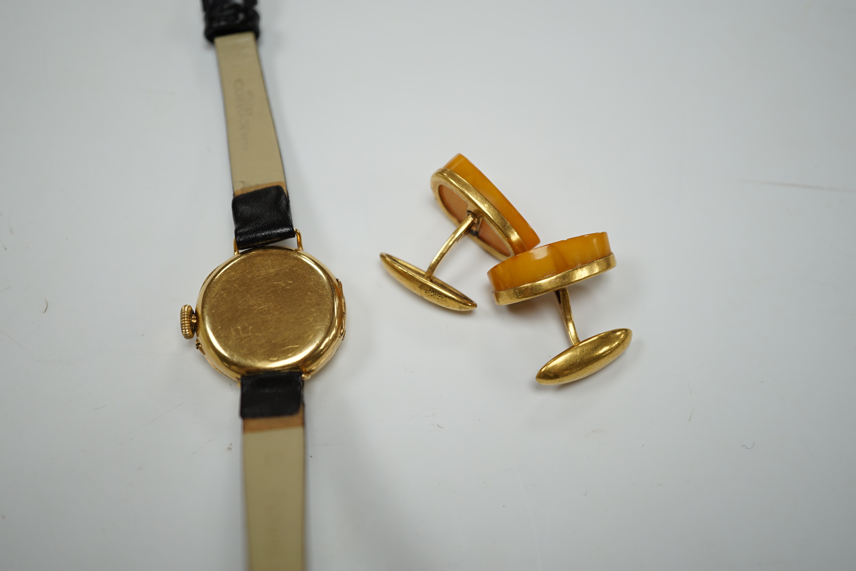 A lady's George V 18ct gold manual wind wrist watch, on later associated leather strap, case hallmarked for London, 1916, together with a pair of amber set gold plated cufflinks.
